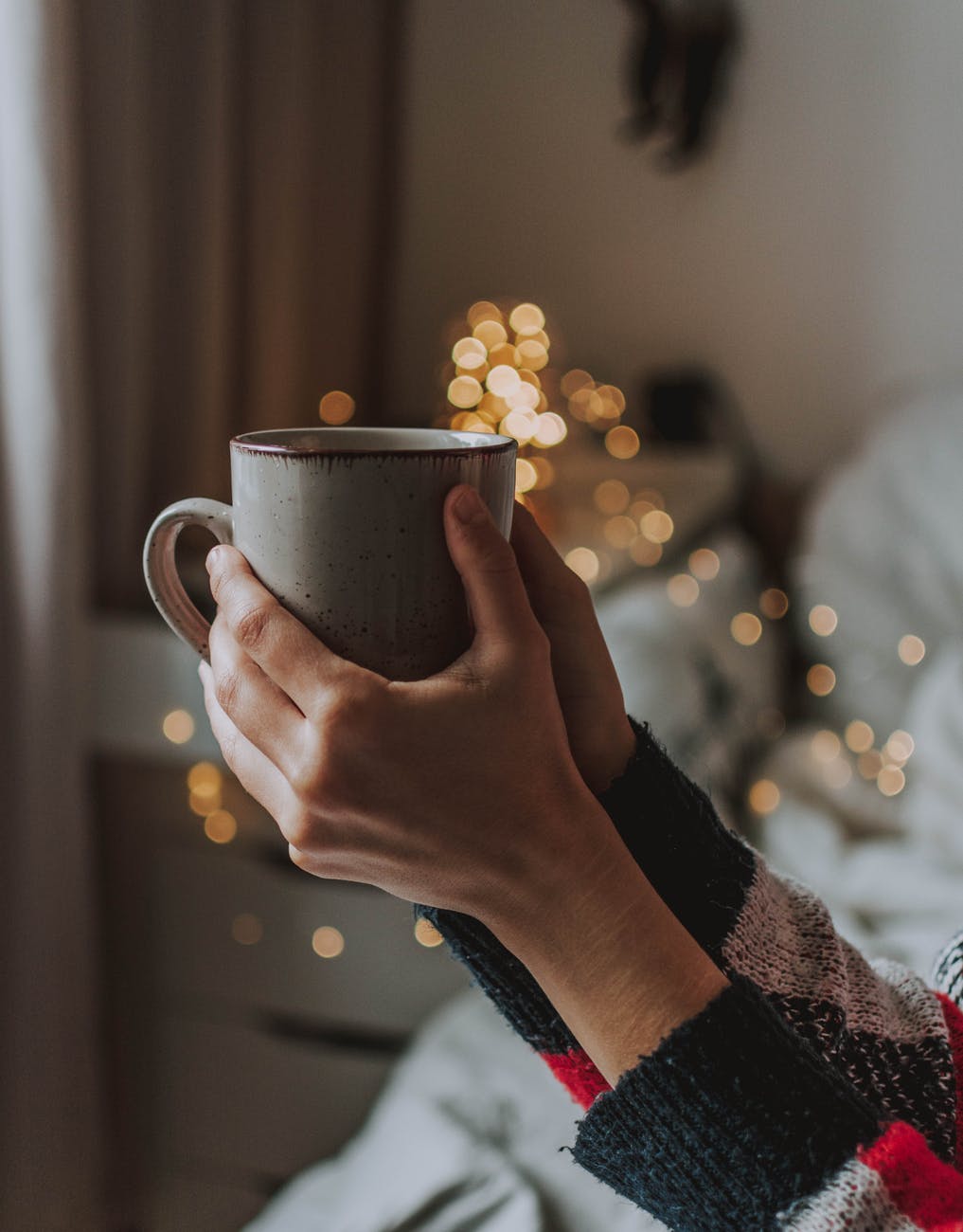 person holding gray mug