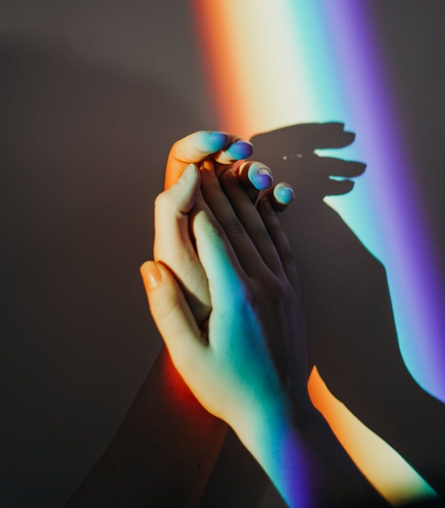 persons hands with rainbow colors