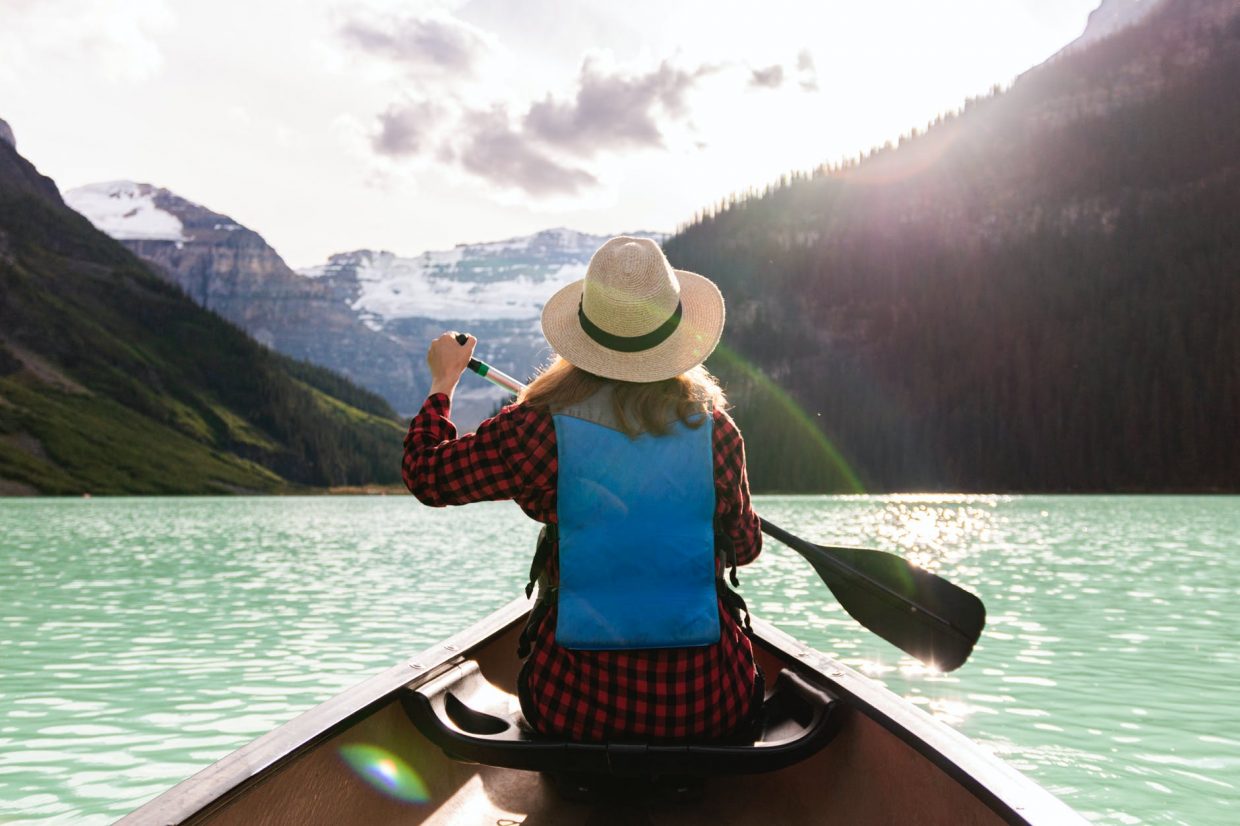 a woman paddling a boat in the lake