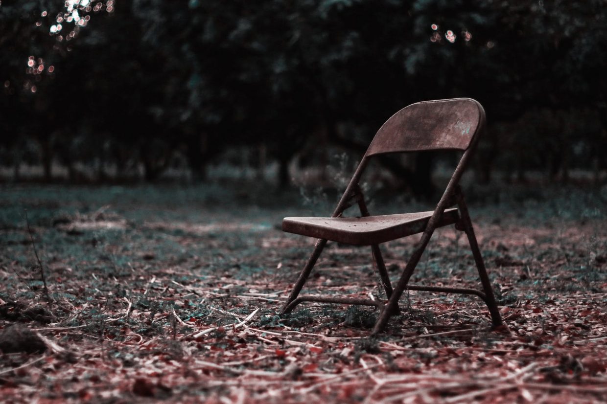 brown wooden folding chair on green grass field